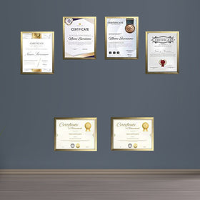 Golden custom diploma frames displaying certificates arranged in a collage on a gray wall above a wooden floor. - Diploma/ Certificate Frames A4 Size - Black / Pack of 2 - Frame World
