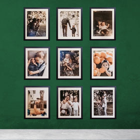 Pack of nine 10x12 inch glass front frames displaying family photos with 7x9 inch print areas on green wall.
