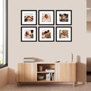 Six black square photo frames arranged in two rows above a wooden sideboard in a modern living space
