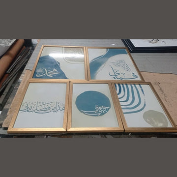 Set of framed artworks with Arabic calligraphy on a table.