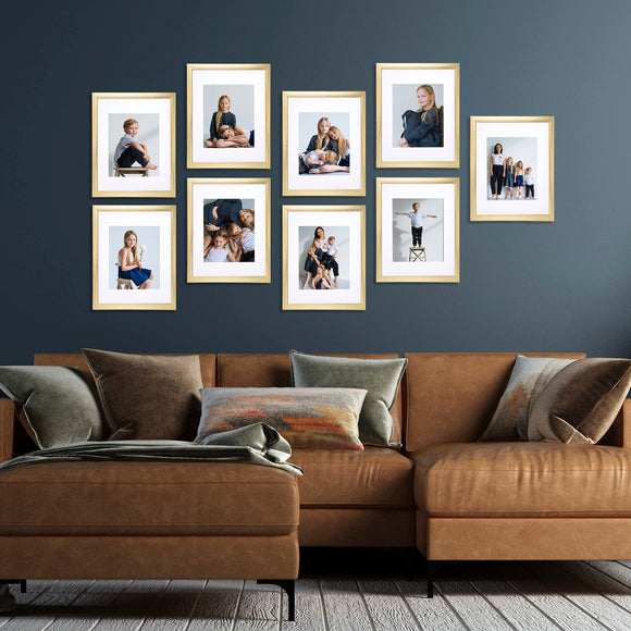A set of A4 picture frames with glass front displayed above a brown sofa, arranged in a collage style.