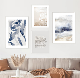 Framed artworks on a wall above a sofa with decorative elements.