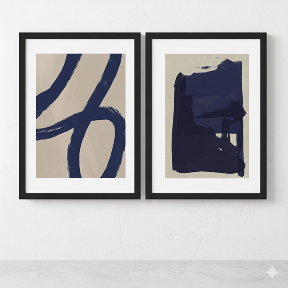 Two abstract artworks with blue brush strokes on beige backgrounds, framed in black, against a white wall.