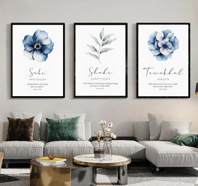 Three framed floral prints above a living room sofa with decorative pillows.