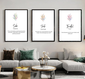 Three framed prints on a wall above a living room sofa with decorative pillows.