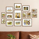 A set of various sized picture frames arranged in a collage on a wall 
