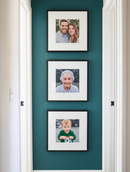 Three framed family photos on a teal wall