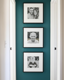 Three framed black and white photos on a teal wall