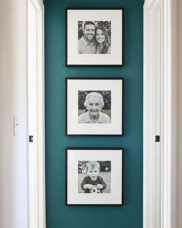 Three framed black and white photos on a teal wall