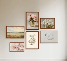 Set of framed artworks on a wall, including floral and landscape scenes.