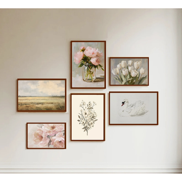 Set of framed artworks on a wall, including floral and landscape scenes.