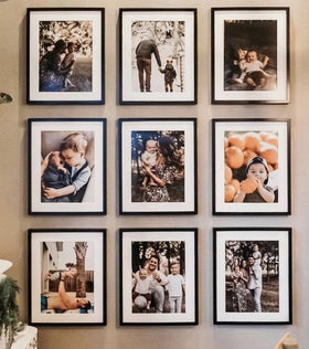 A collection of nine framed photographs of various people, arranged in a grid pattern on a wall.