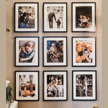 A collection of nine framed photographs of various people, arranged in a grid pattern on a wall.