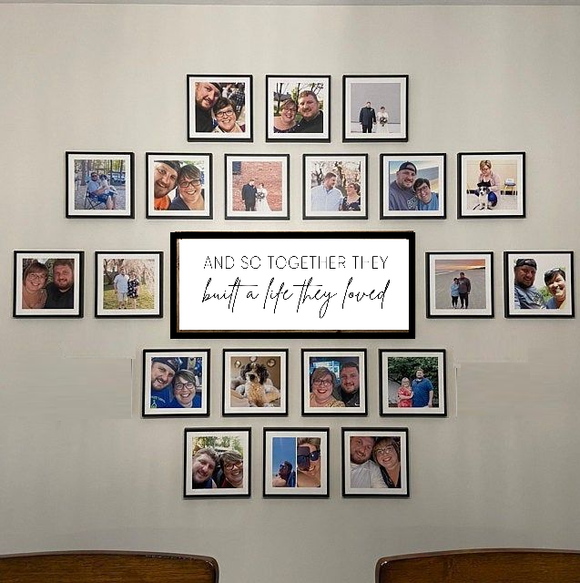 A wall-mounted photo frame set containing 21 frames of various sizes, displaying a collection of family photos with a central text frame stating 'And so together they built a life they loved'.
