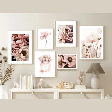 Set of floral prints on a wall above a console table.