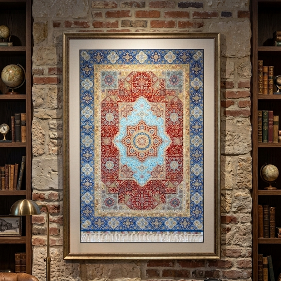 A large framed oriental rug with a red, blue, and beige pattern hangs on a rustic brick wall in a study with bookshelves and a desk.