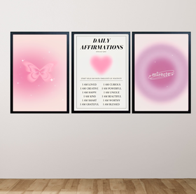Three framed prints on a wall with pink and purple abstract designs and text.