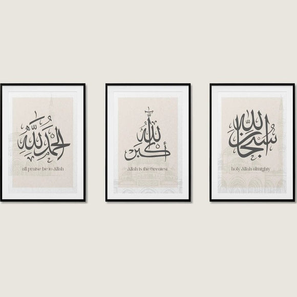 Three framed calligraphy artworks with Arabic script, displayed on a wall. Each frame has a different color: black, white, and gold.