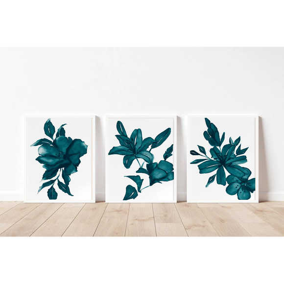 Three teal floral prints on a white wall with a wooden floor.